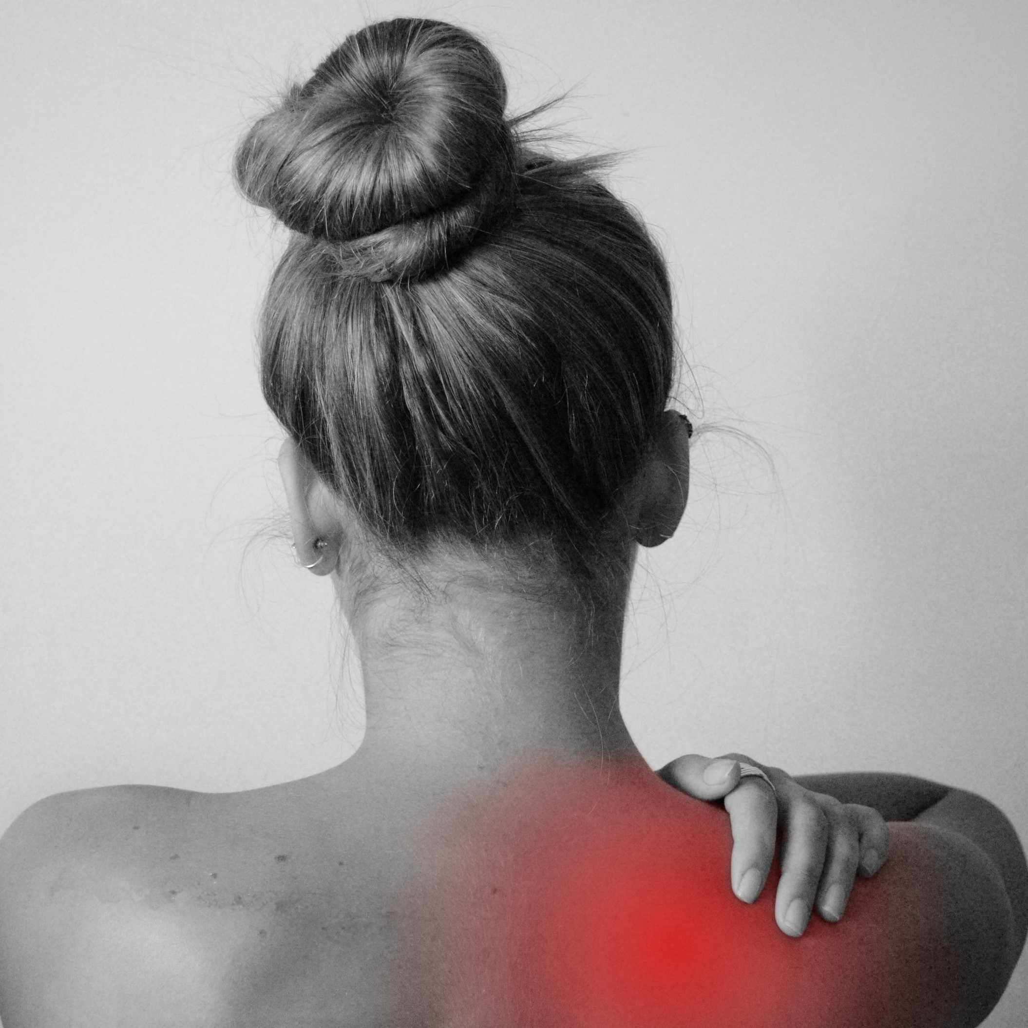 Women holding aching shoulder with pain shown in red.